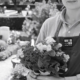Personne tenant un bouquet de fleurs au cimetière, prêt à fleurir une tombe à distance.