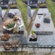 Deux tombes au cimetière décorées de bouquets et fleurs; l’une avec un grand bouquet posé sur la pierre, l’autre avec des petites fleurs et une urne gravée.