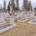 File alt: Cimetière paisible avec de nombreuses tombes rectangulaires en pierre blanche et des croix, sur un terrain herbeux, arbres et maisons en arrière-plan. qu'est-ce qu'un lieu de recueillement intégré.