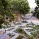 Vue d’un jardin urbain soigné et arboré, avec allées géométriques et plantations mixtes; des personnes se promènent.