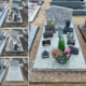 Tombe gravée et stèles en pierre dans un cimetière, avec décor floral et gravures, vue principale sur la tombe principale